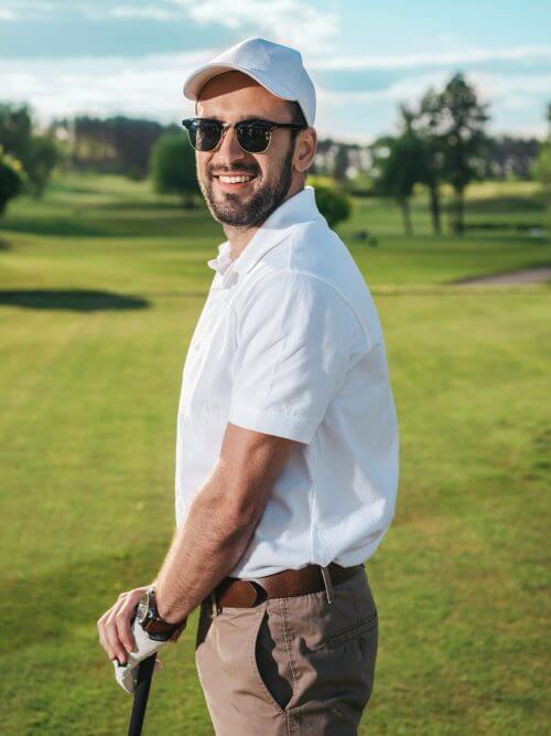 handsome-man-in-sunglasses-holding-golf-club-and-smiling-at-camera-e1633333940959.jpg